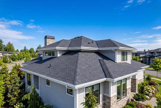 Suburban home with a new gray shingle roof and gutters