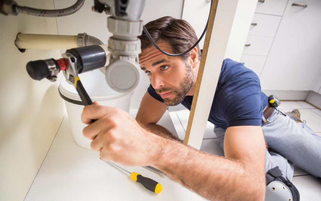 Plumber repairing a sink drain — illustrative stock photo, not an actual A&T Service Plumbing job