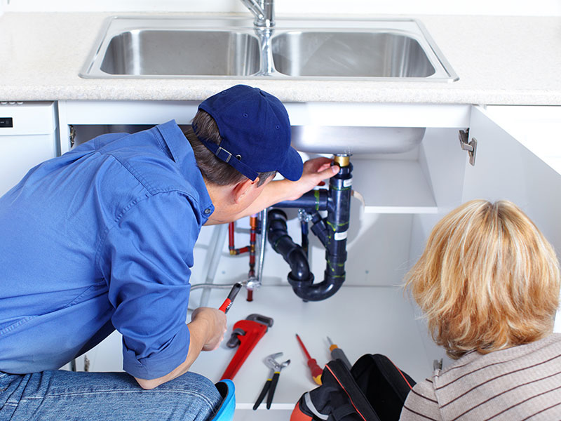 Plumber at work in a kitchen