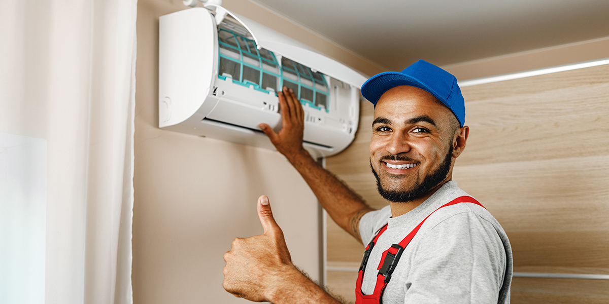 A technician installing an air conditioner for Air Solutions Mechanical Ltd
