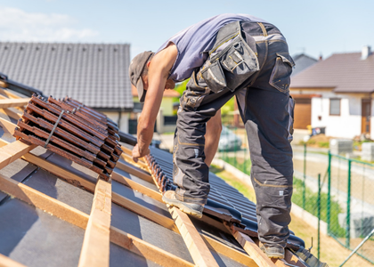 Roofer installing tiles on a residential roof