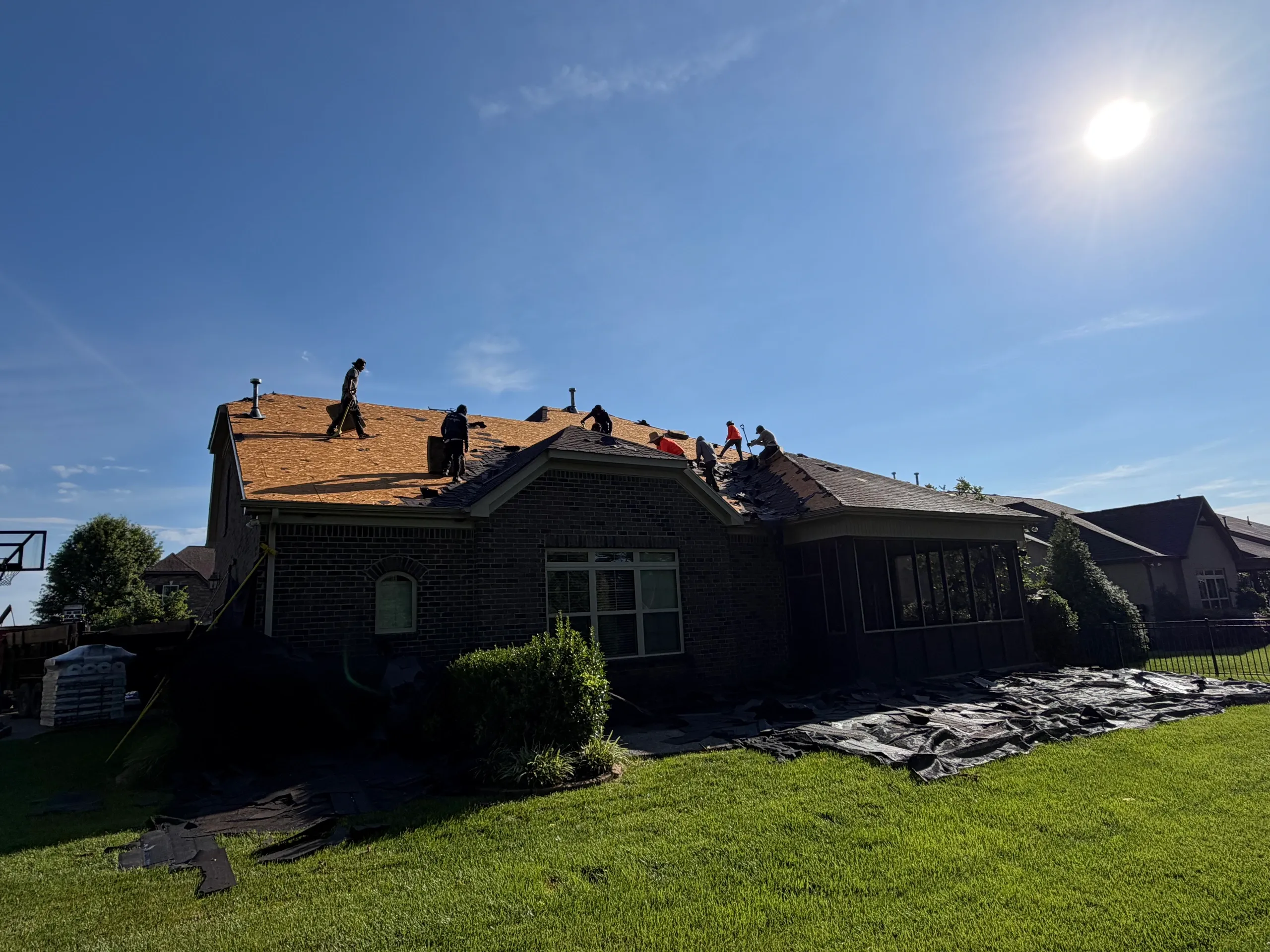 Crew tearing off an old shingle roof