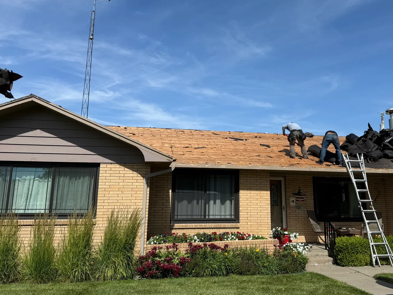 Roofers removing old roofing material