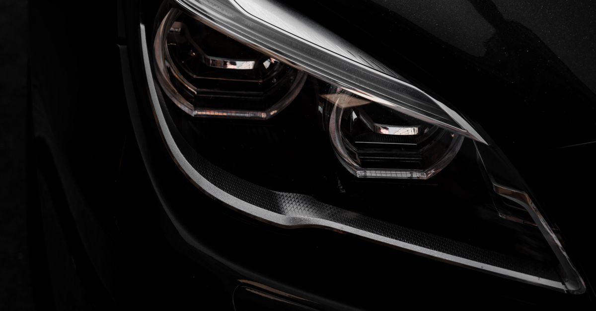 Close-up of a polished headlight on a black car