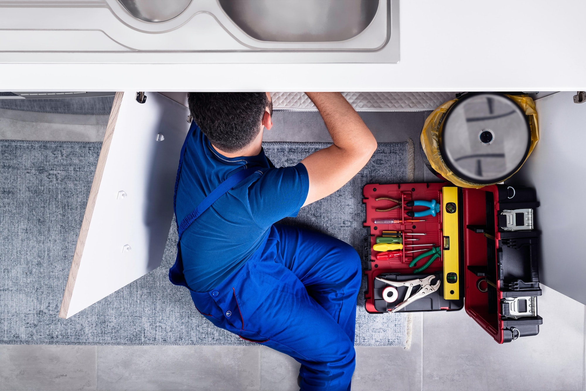 Concept illustration of a plumber installing a kitchen sink