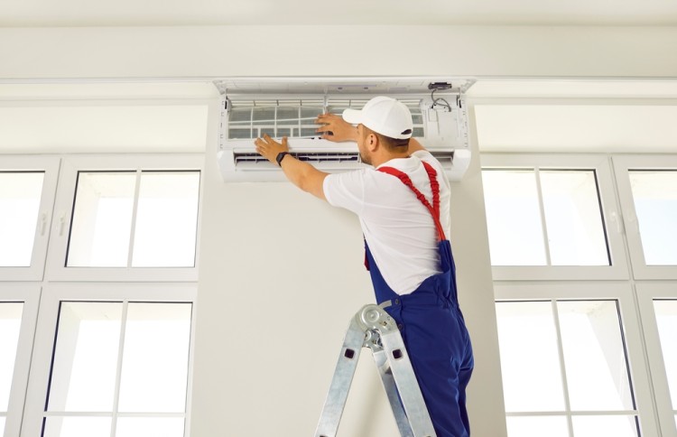 Illustrative photo of a technician repairing a split system air conditioner