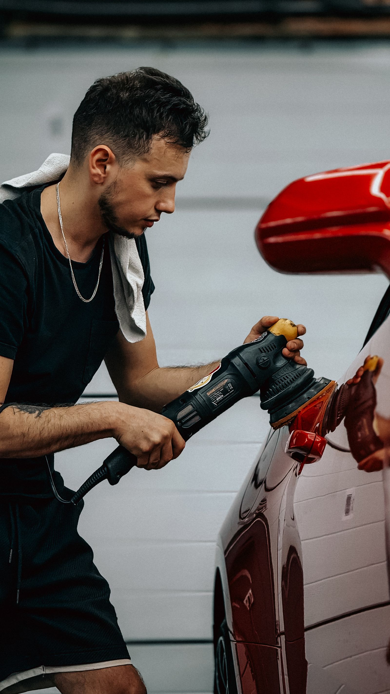 Technician machine-polishing a car at Blitz Auto Spa