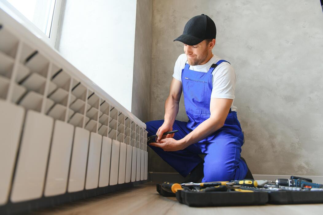 Plumber checking a radiator during installation