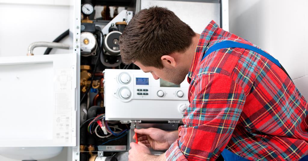 Heating engineer fitting a domestic boiler