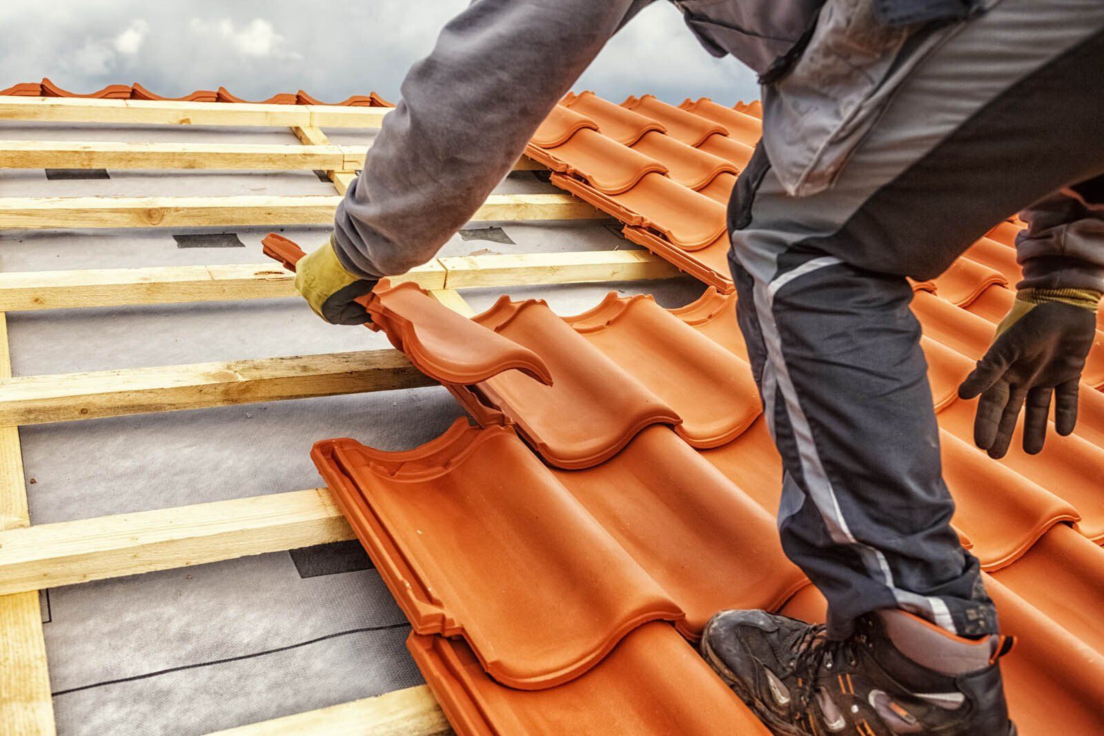 Roofer laying roof tiles