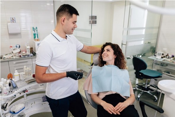 Dentist talking with a smiling patient in the surgery