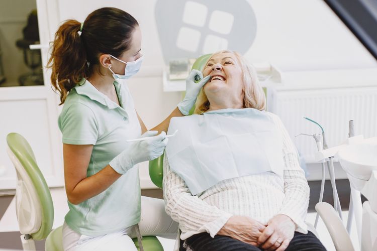Dental hygienist with a smiling patient at a Calgary dental clinic