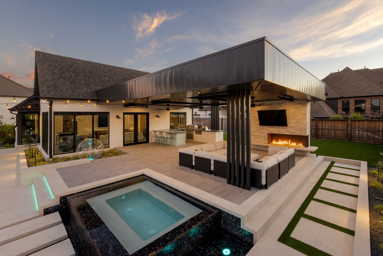 Resort-style Texas backyard with custom pool, stone patio and evening light
