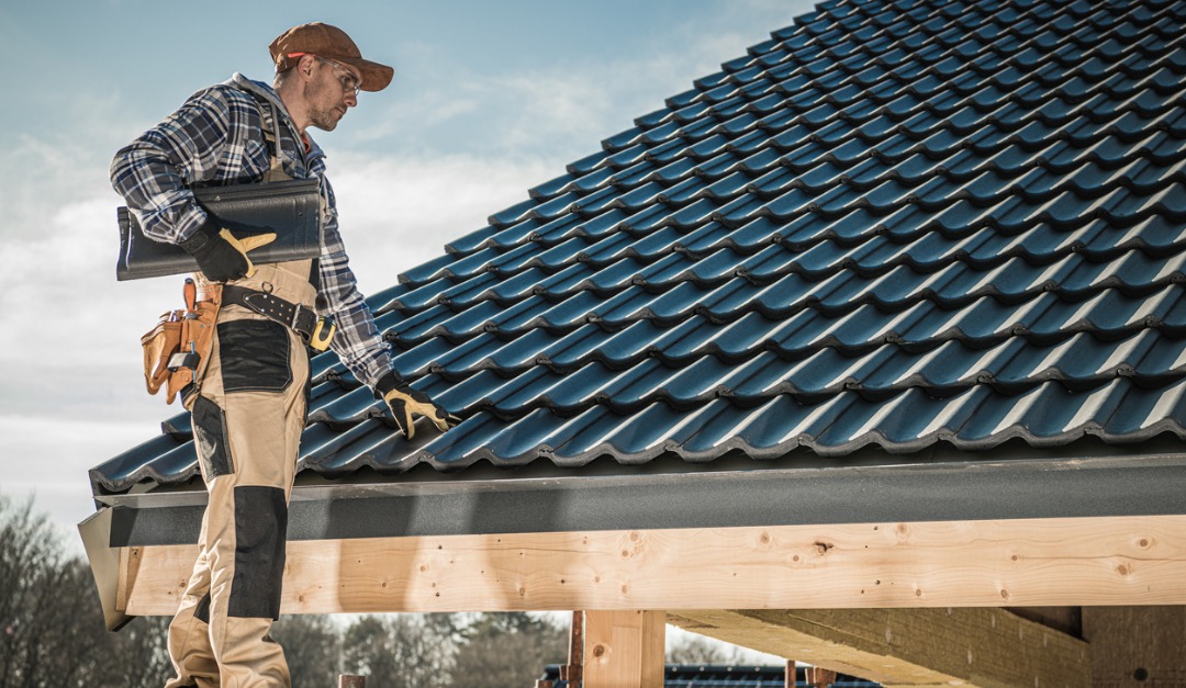 Roofer fitting tiles on a home (illustrative photo)