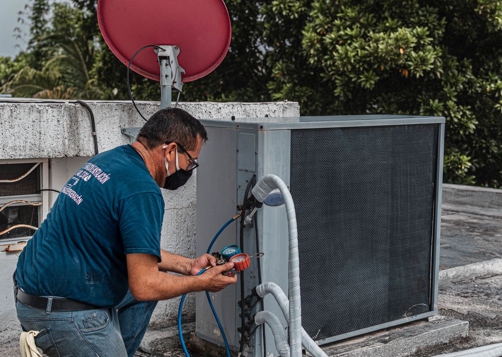 Illustrative stock photo: technician servicing an air conditioning unit
