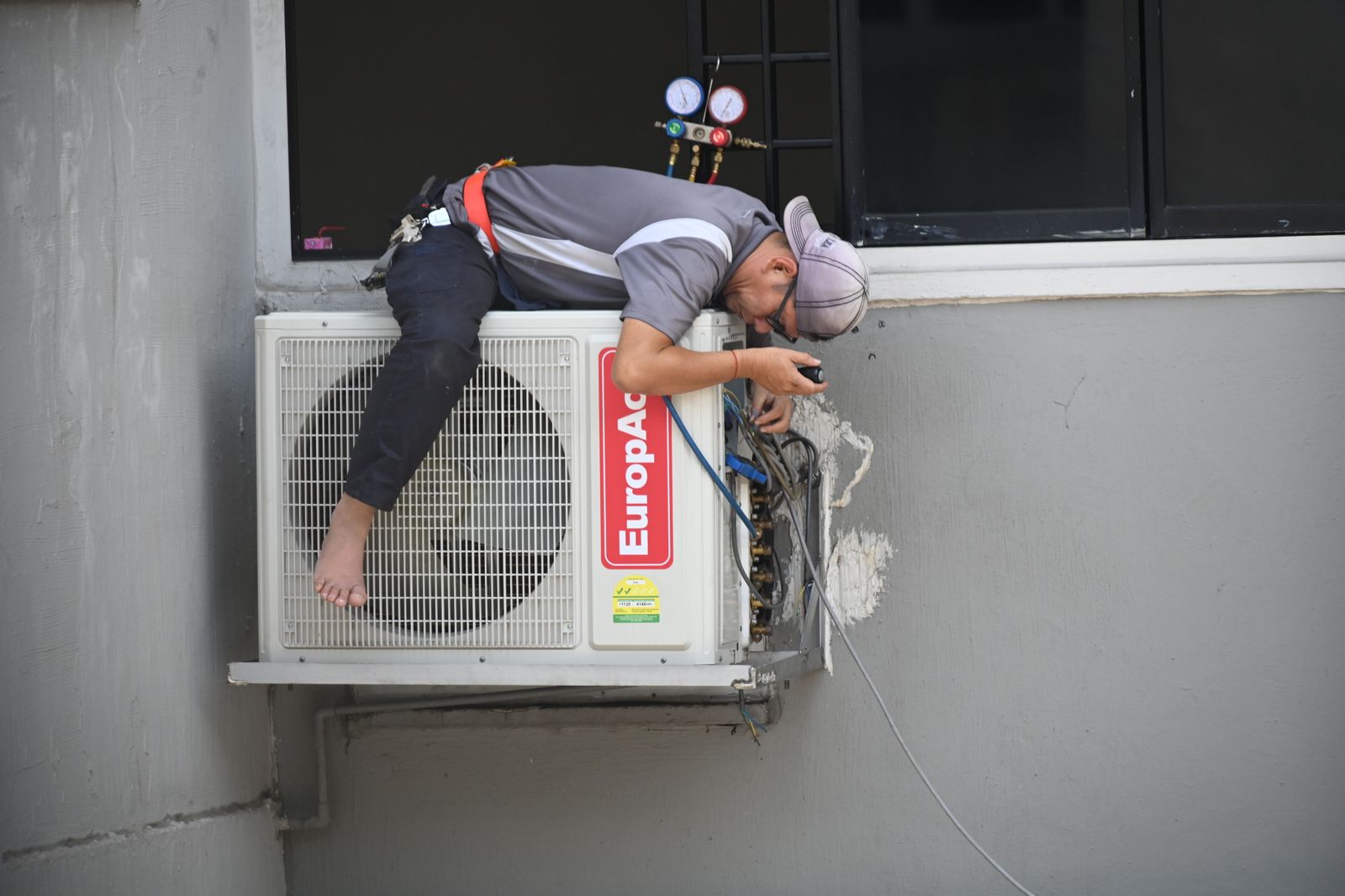 Technician performing air conditioning service at a home
