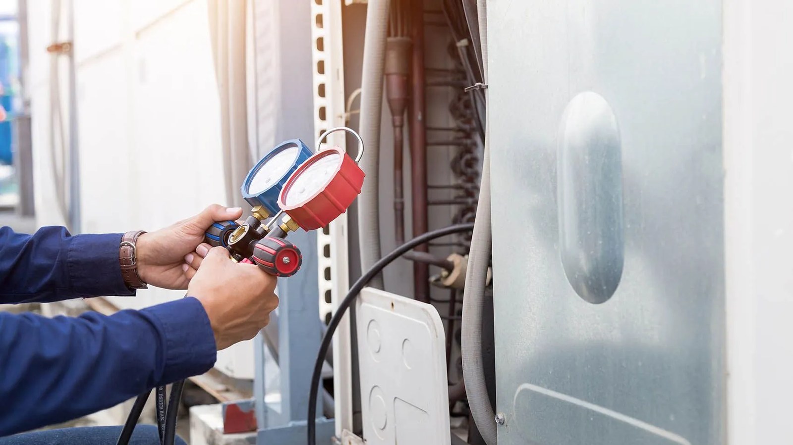 Technician checking refrigerant gauges on a heat pump