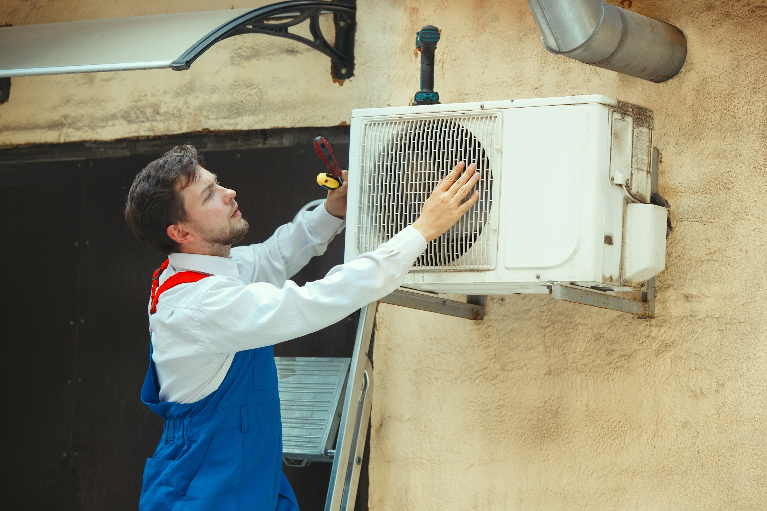 Technician repairing an outdoor air conditioner