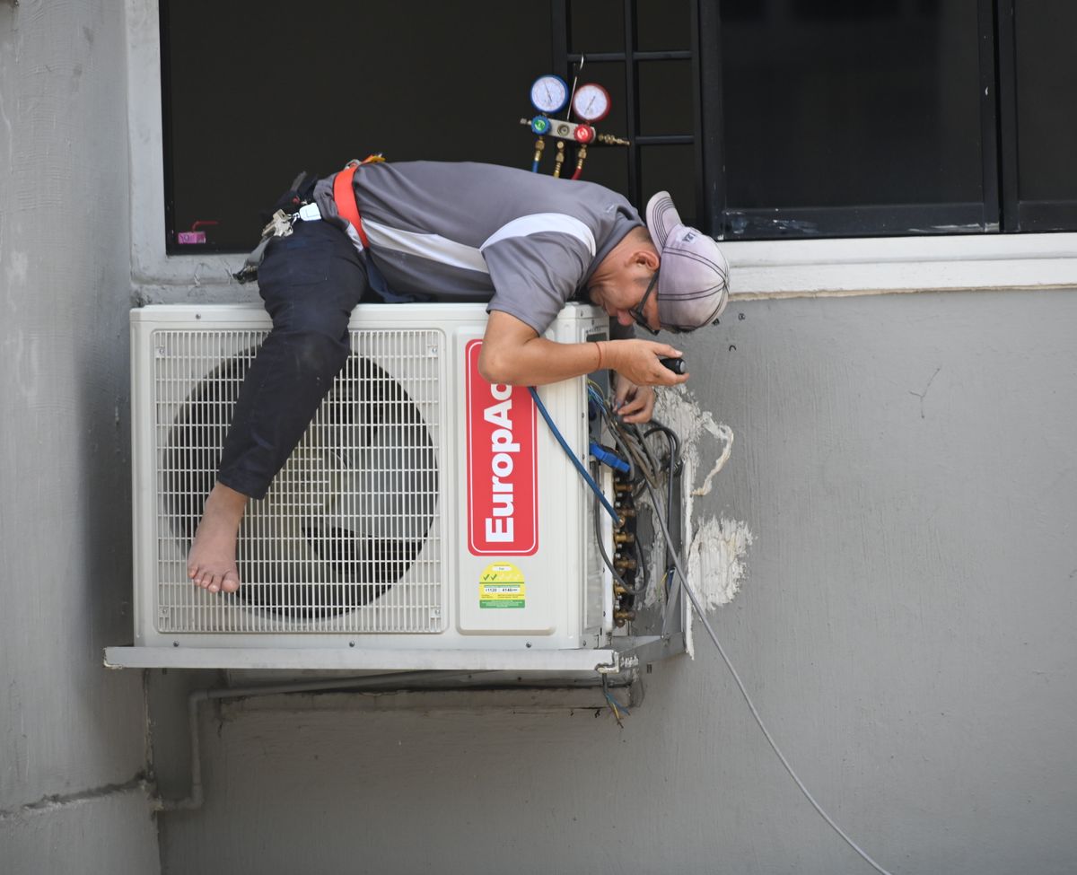 Air conditioning technician servicing an outdoor unit in Houston