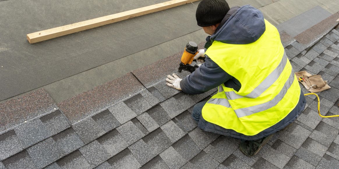Roofer installing asphalt shingles