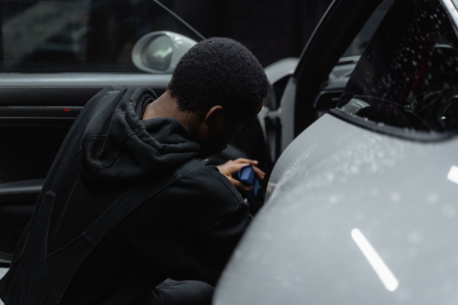 Detailer carefully cleaning a luxury car interior