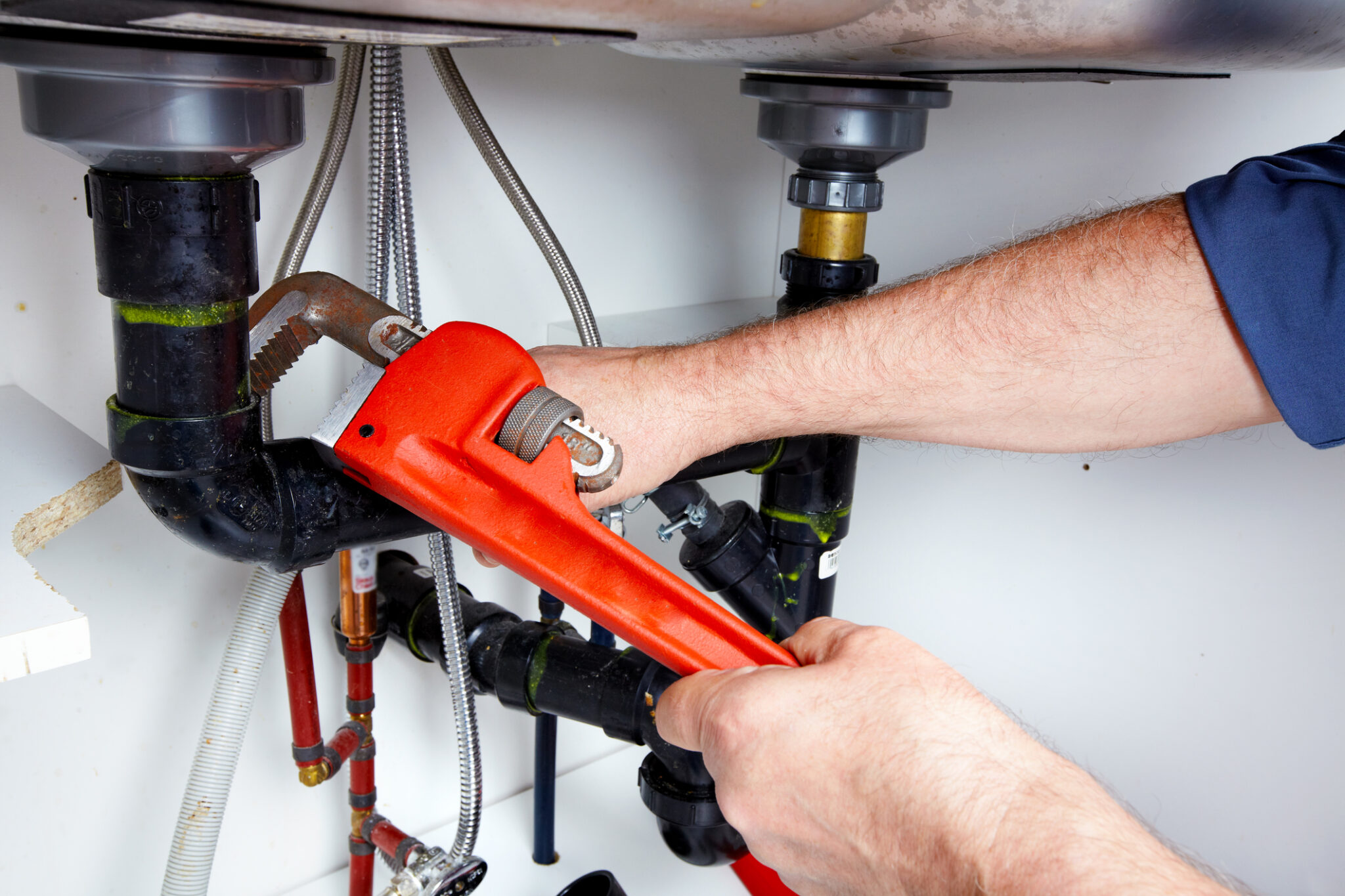 Halo plumber tightening a fitting with a wrench