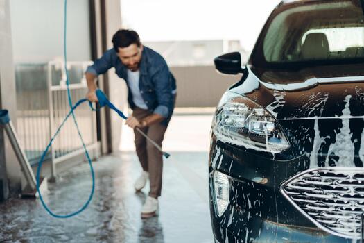 High-pressure wash lifting dirt off a car's bodywork