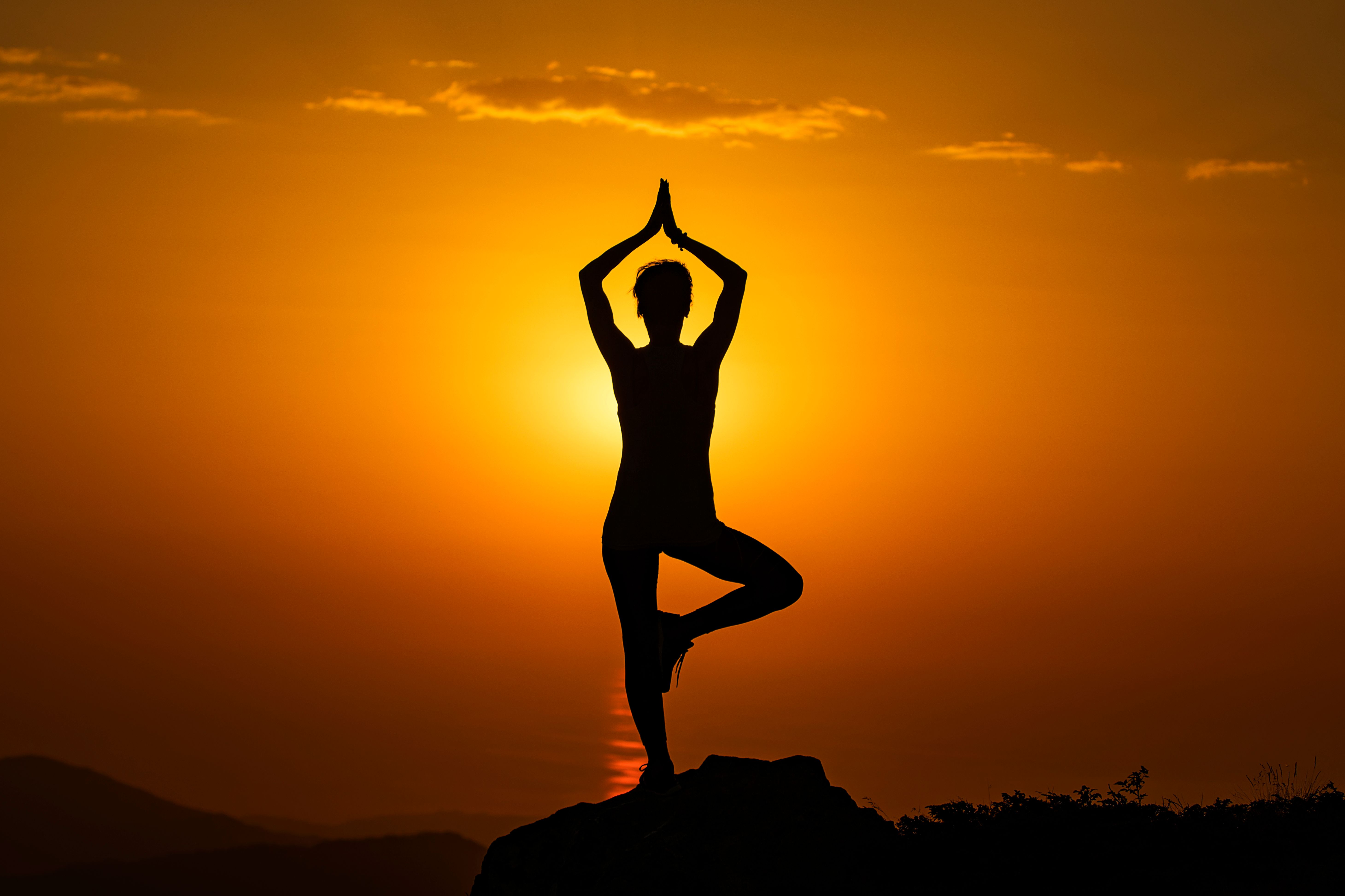 Silhouette of a yoga pose at sunset