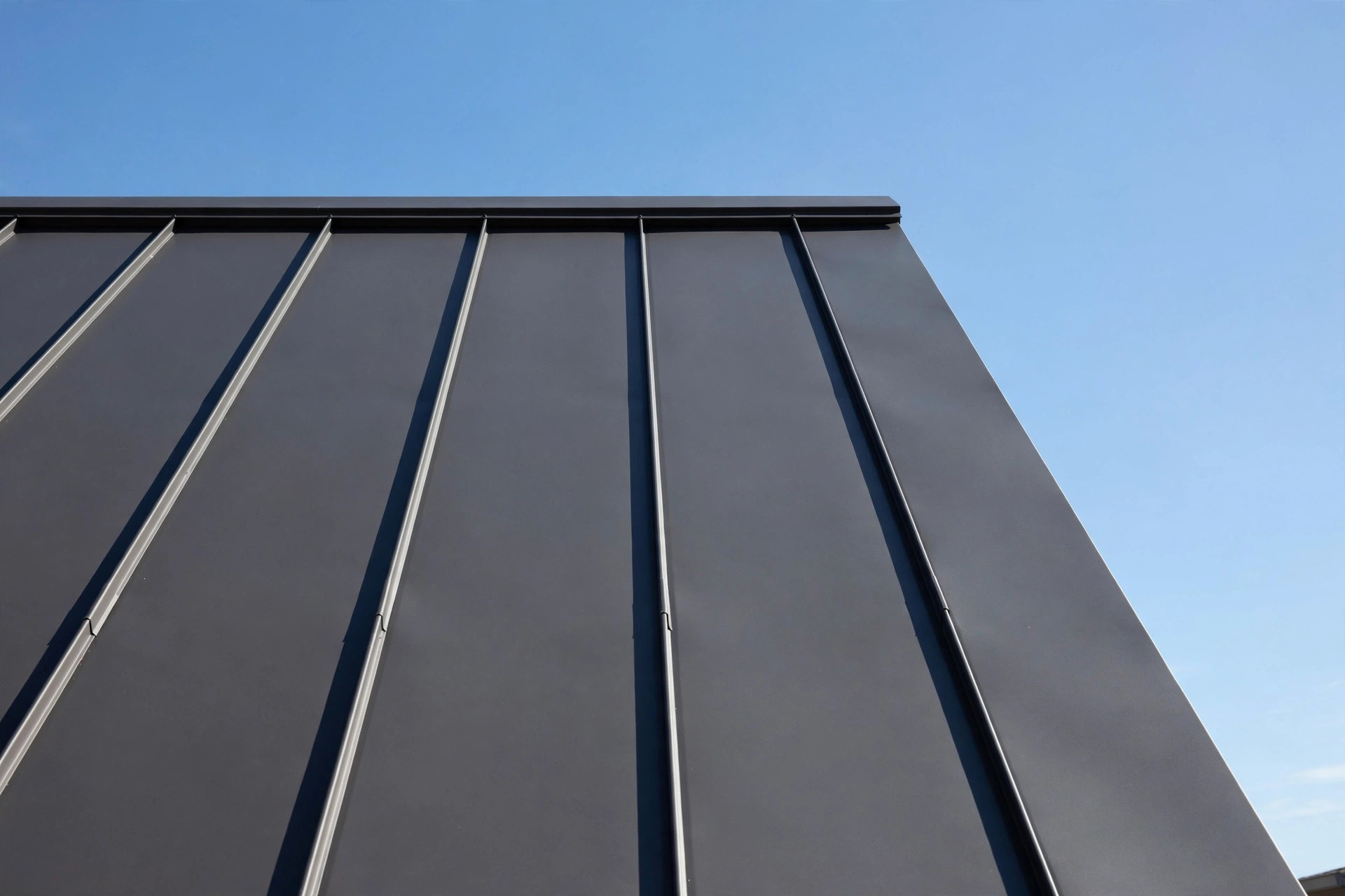 Standing-seam metal roof detail against a clear sky