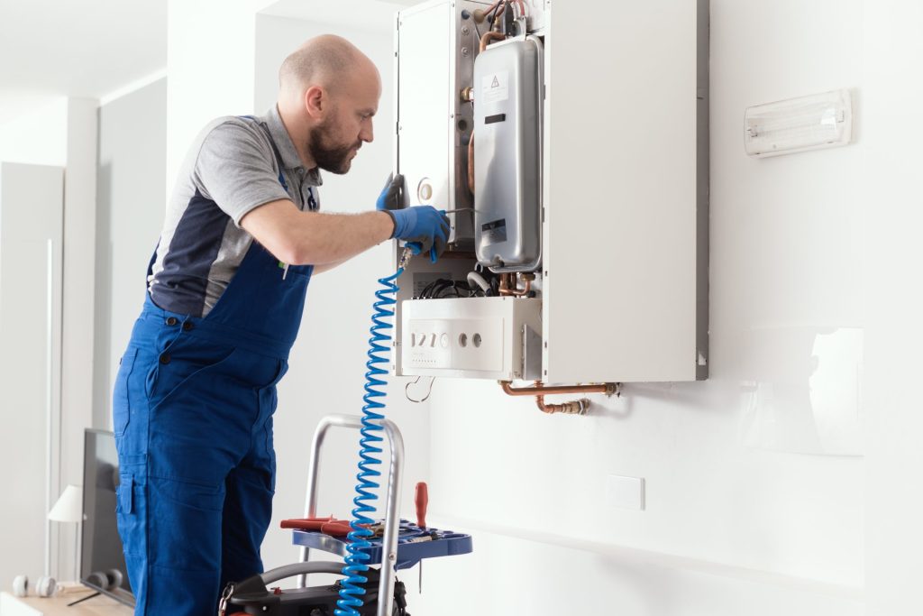 Gas Safe engineer servicing a wall-mounted boiler