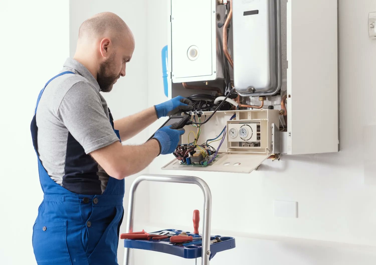 Illustrative photo: engineer servicing a heating system