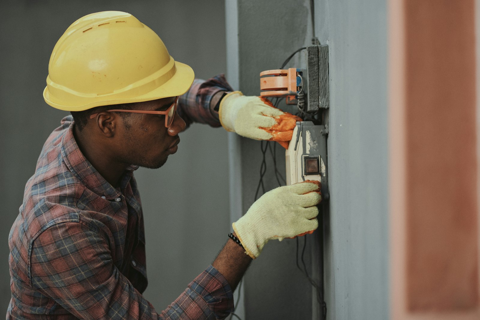 Technician installing a heat pump control unit on a wall