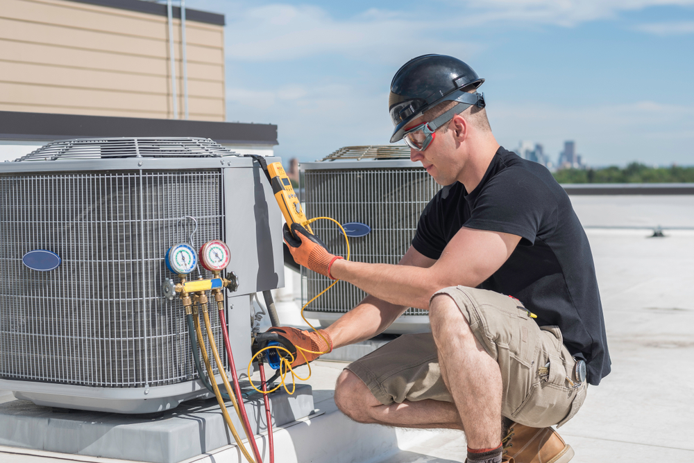 Technician performing seasonal maintenance on HVAC equipment