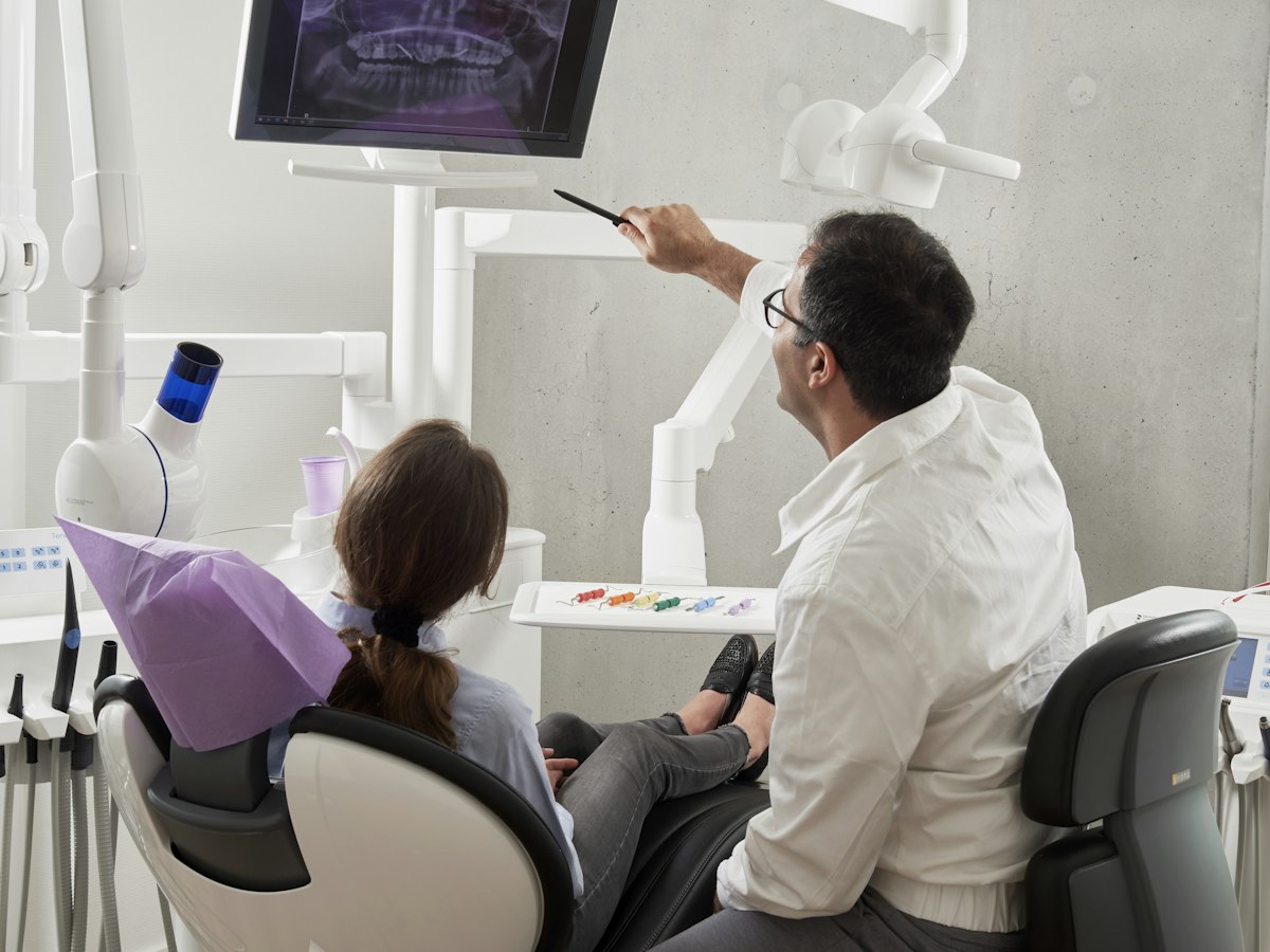 Dentist talking through treatment options with a patient in a bright modern clinic