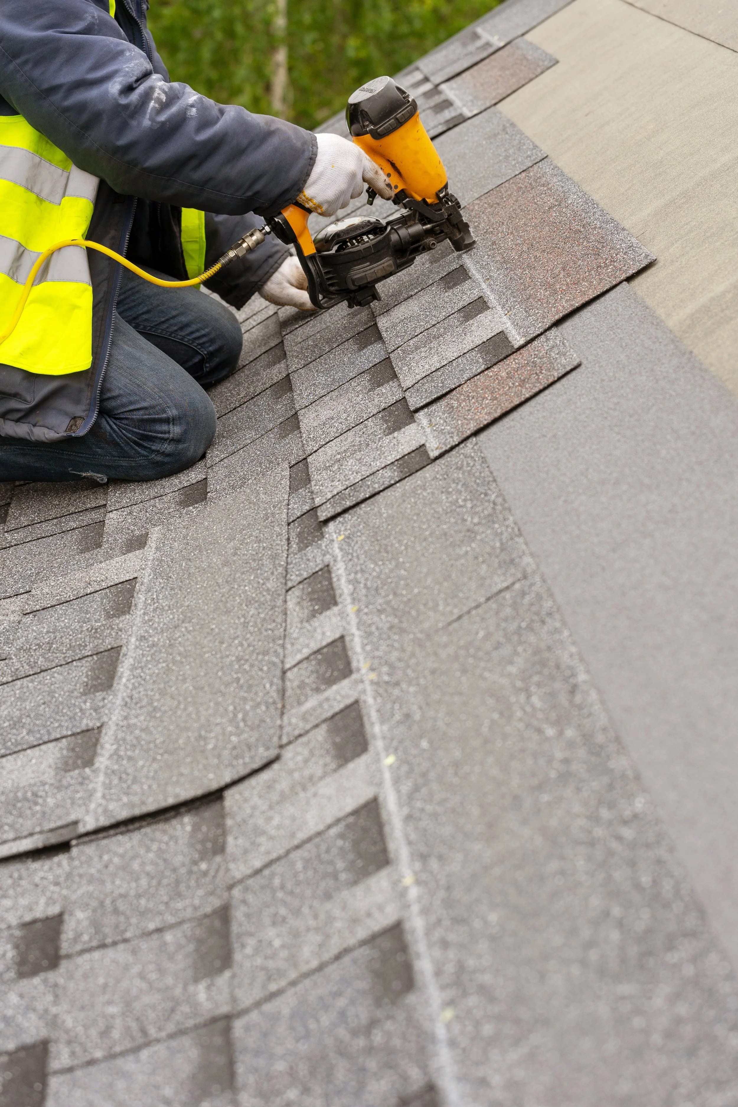 Roofer installing shingles