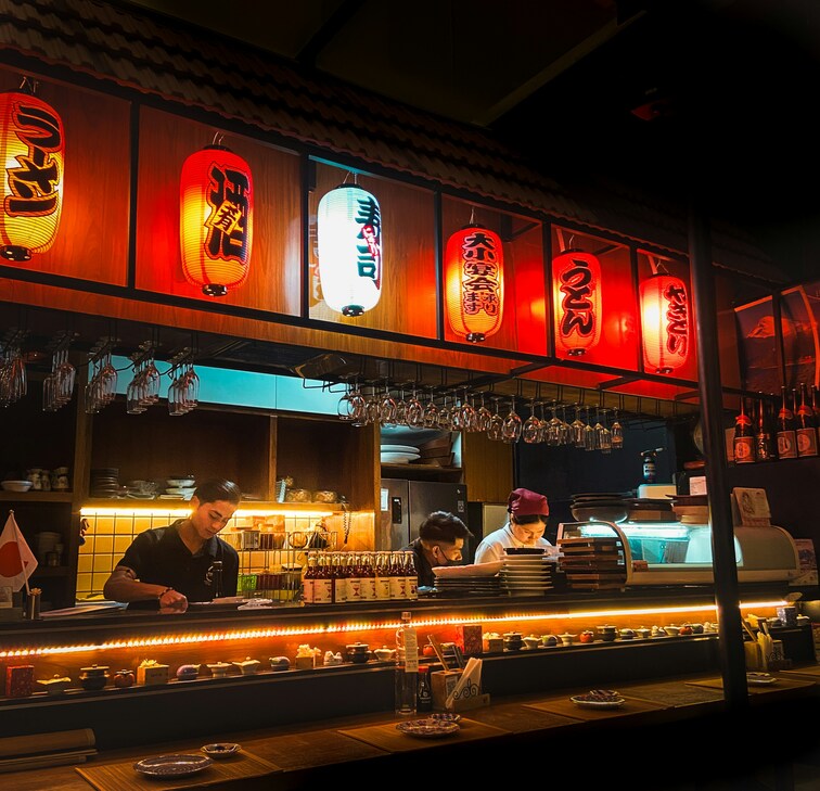 Japanese restaurant interior with lanterns and chefs at the counter