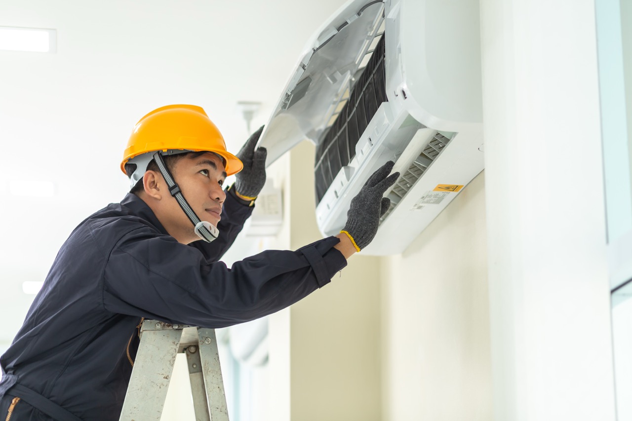 Technician servicing an air conditioning unit