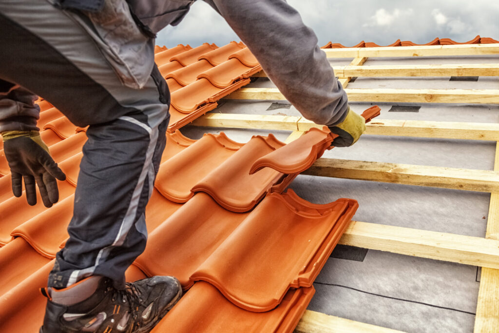 Roofer laying roof tiles