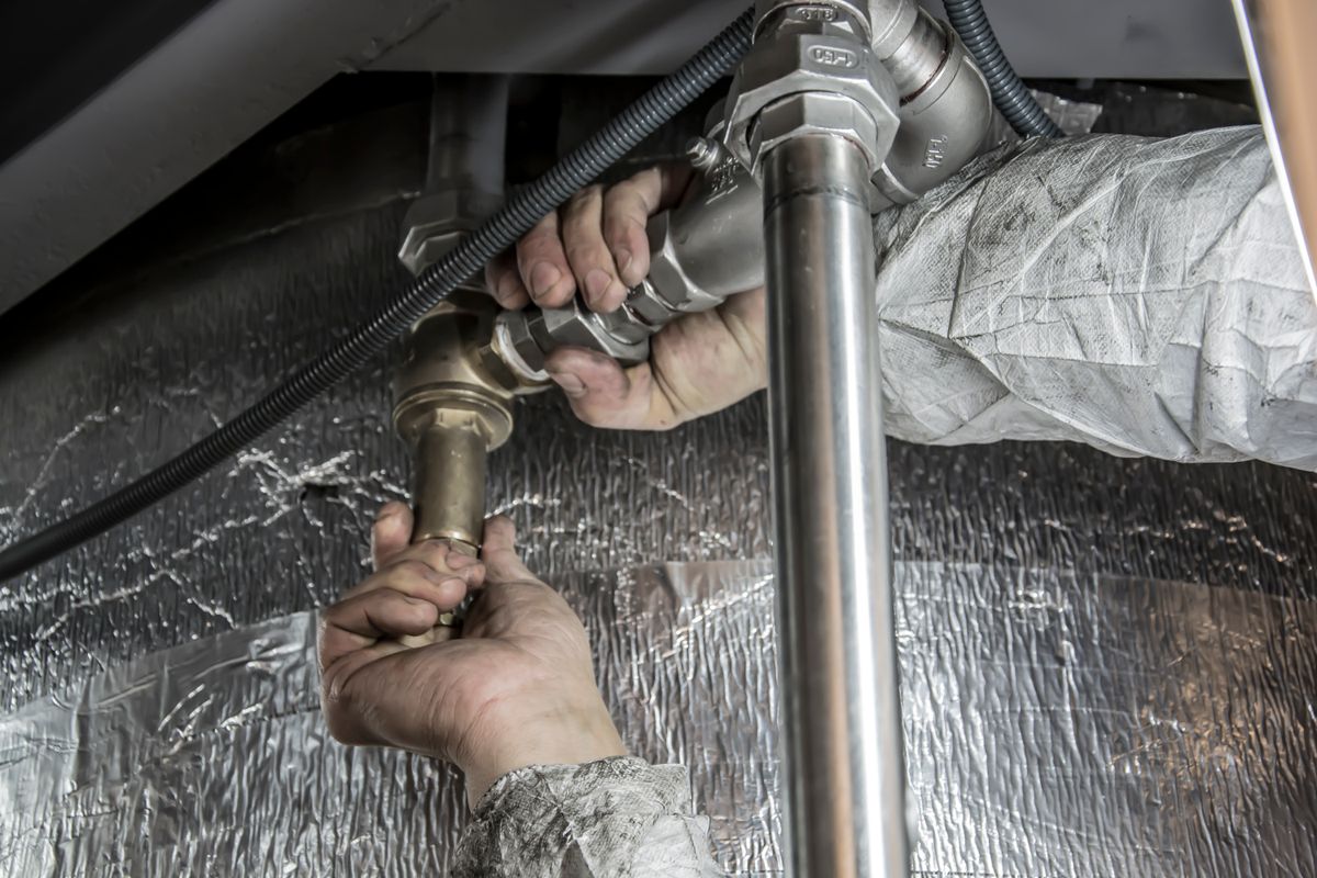 Plumber's hands fitting metal drain pipes