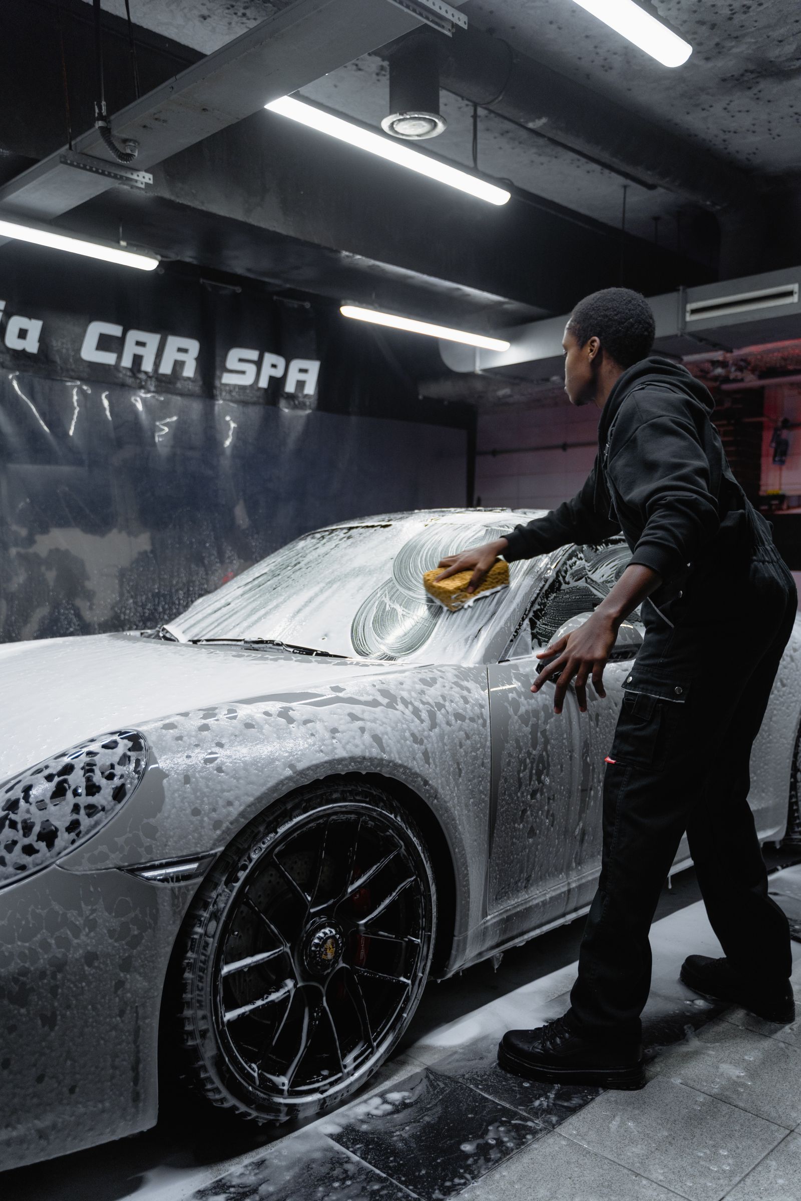 Hand washing a car with foam at a Glasgow detailing studio