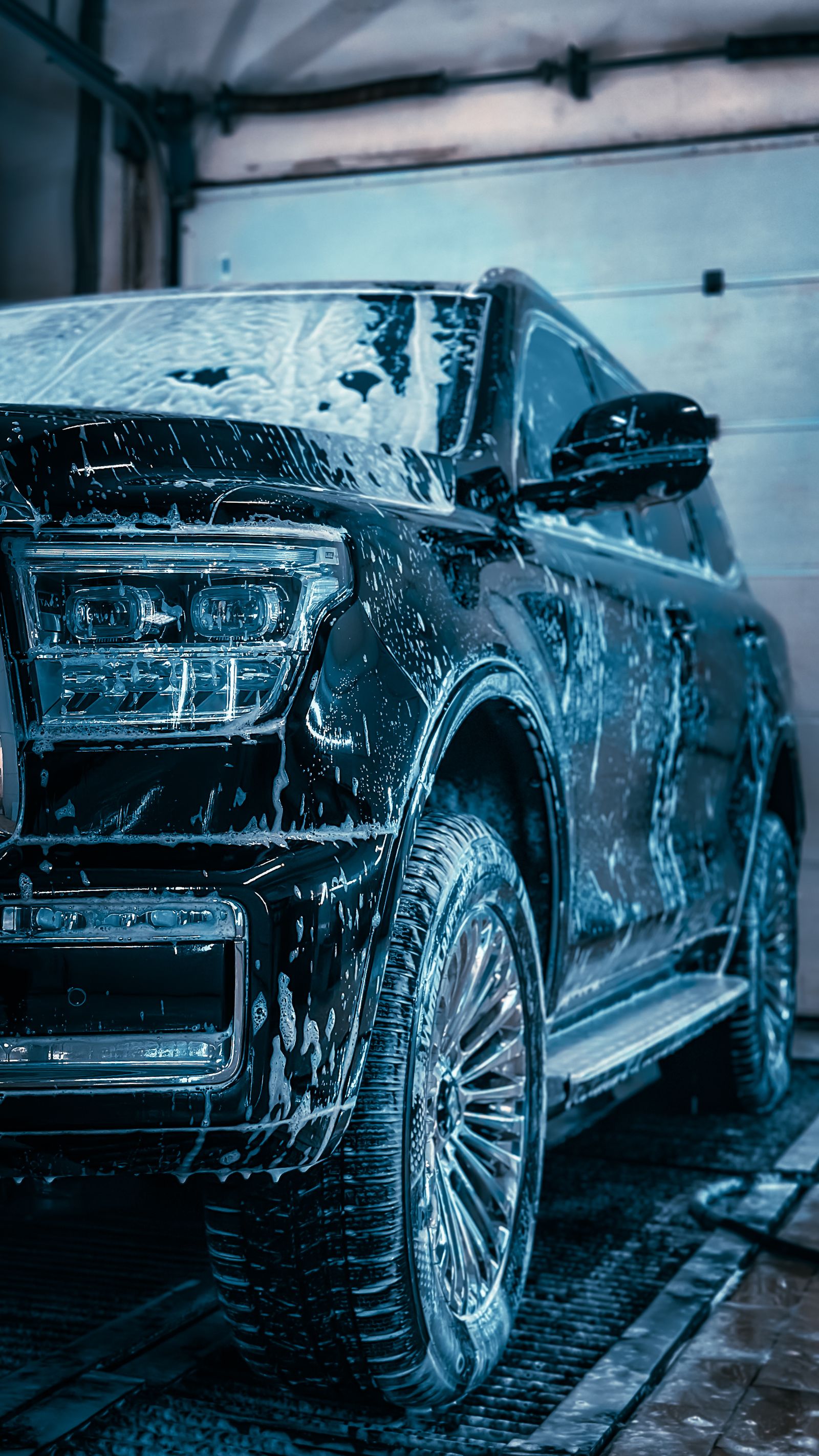 SUV covered in foam during a hand wash