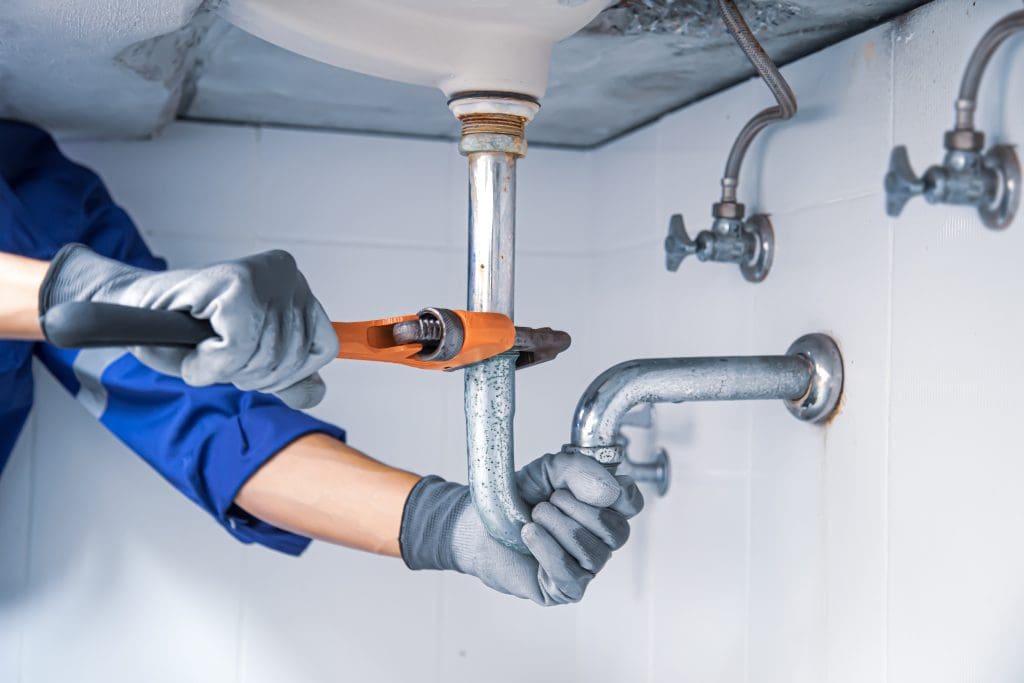 Pioneer plumber repairing a sink drain