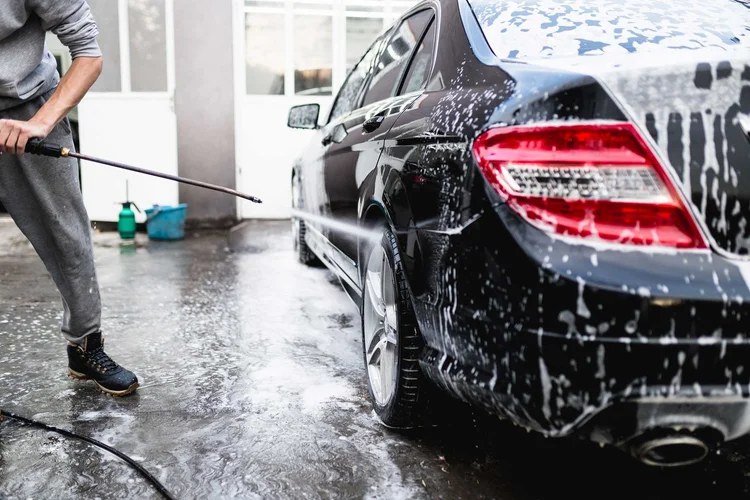 Foam wash on a black sedan during a mobile detail