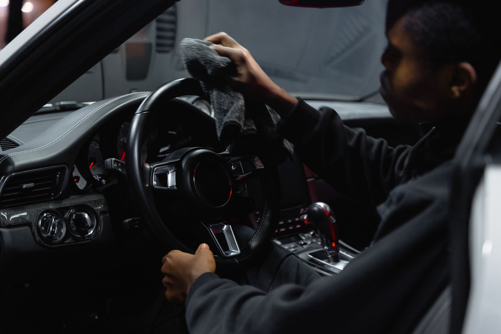 Detailer wiping a steering wheel during an interior detail