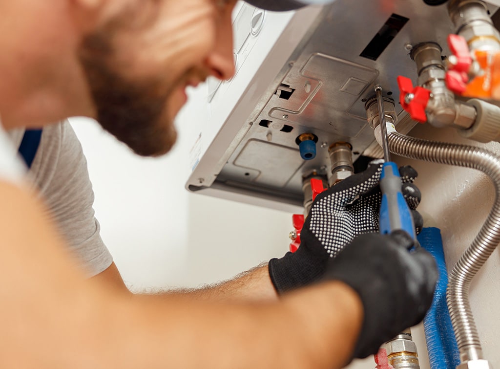 Technician servicing heating equipment