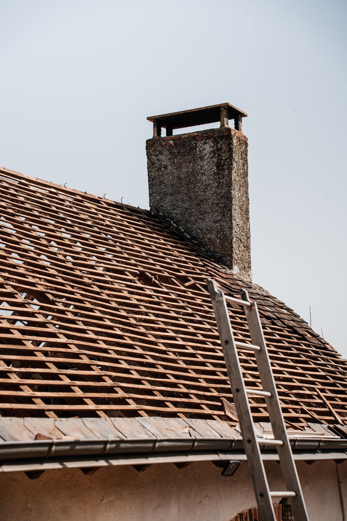 Roof with ladder and chimney during repair