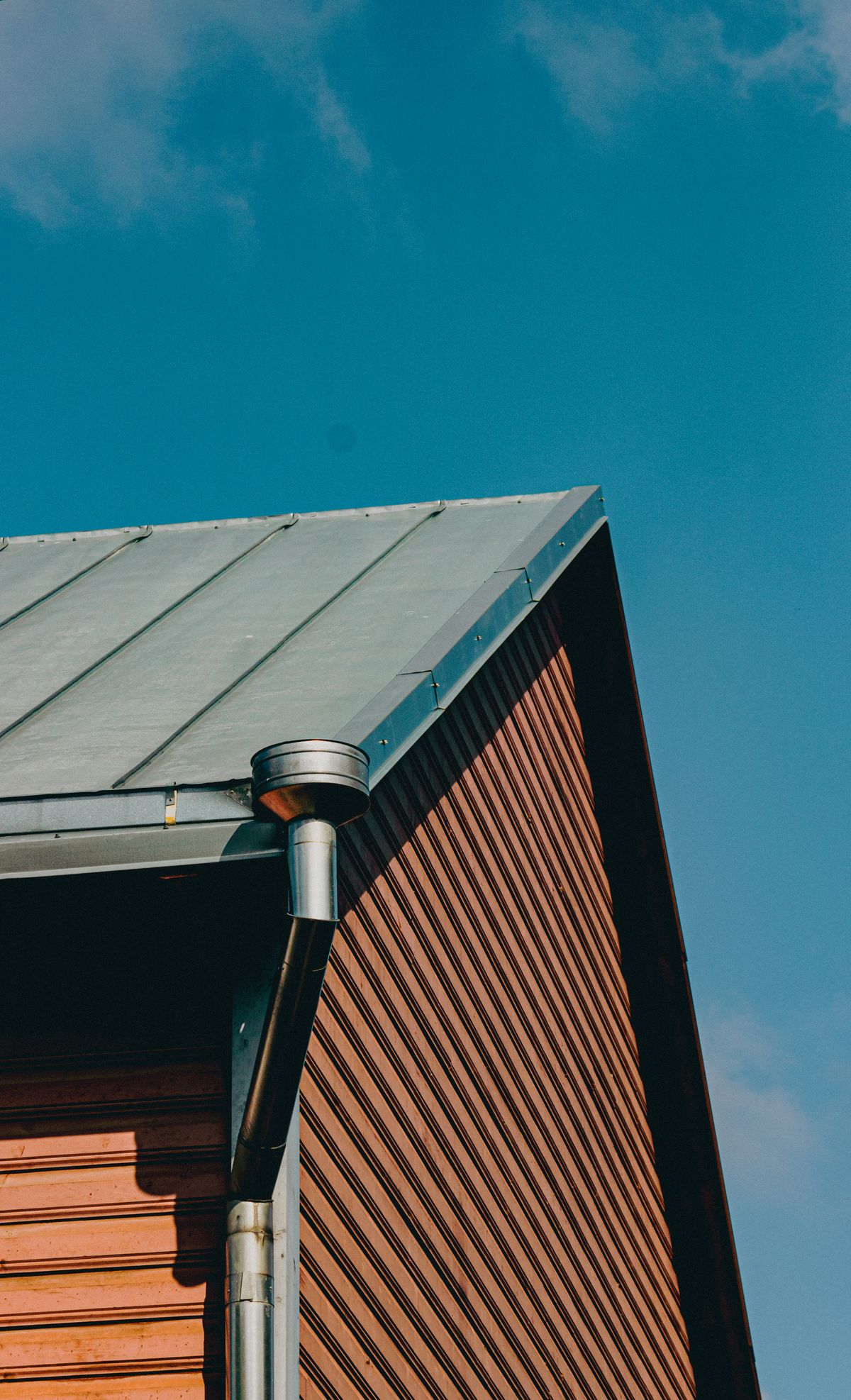 Metal roof corner with gutter and downpipe