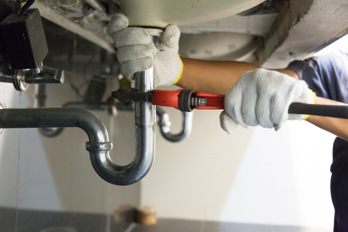 Technician repairing a sink pipe