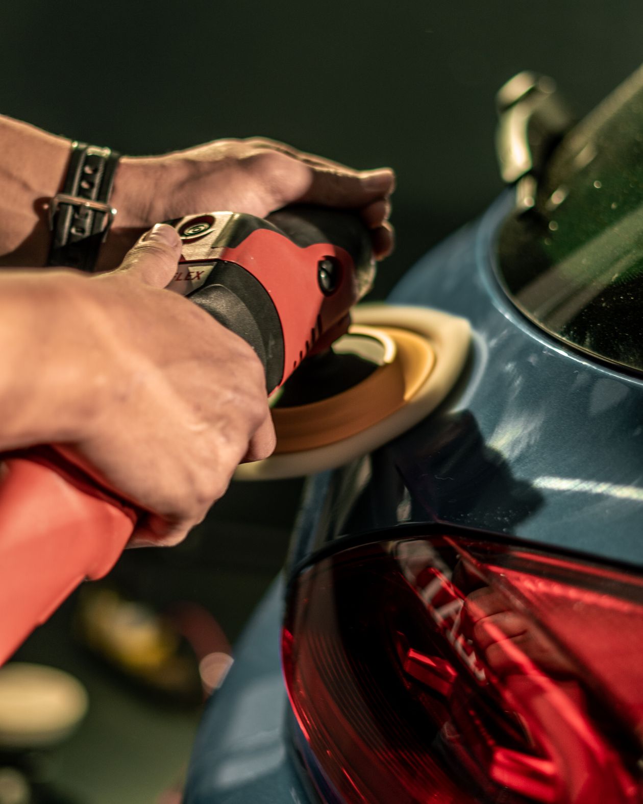 Technician machine-polishing a car to a deep gloss