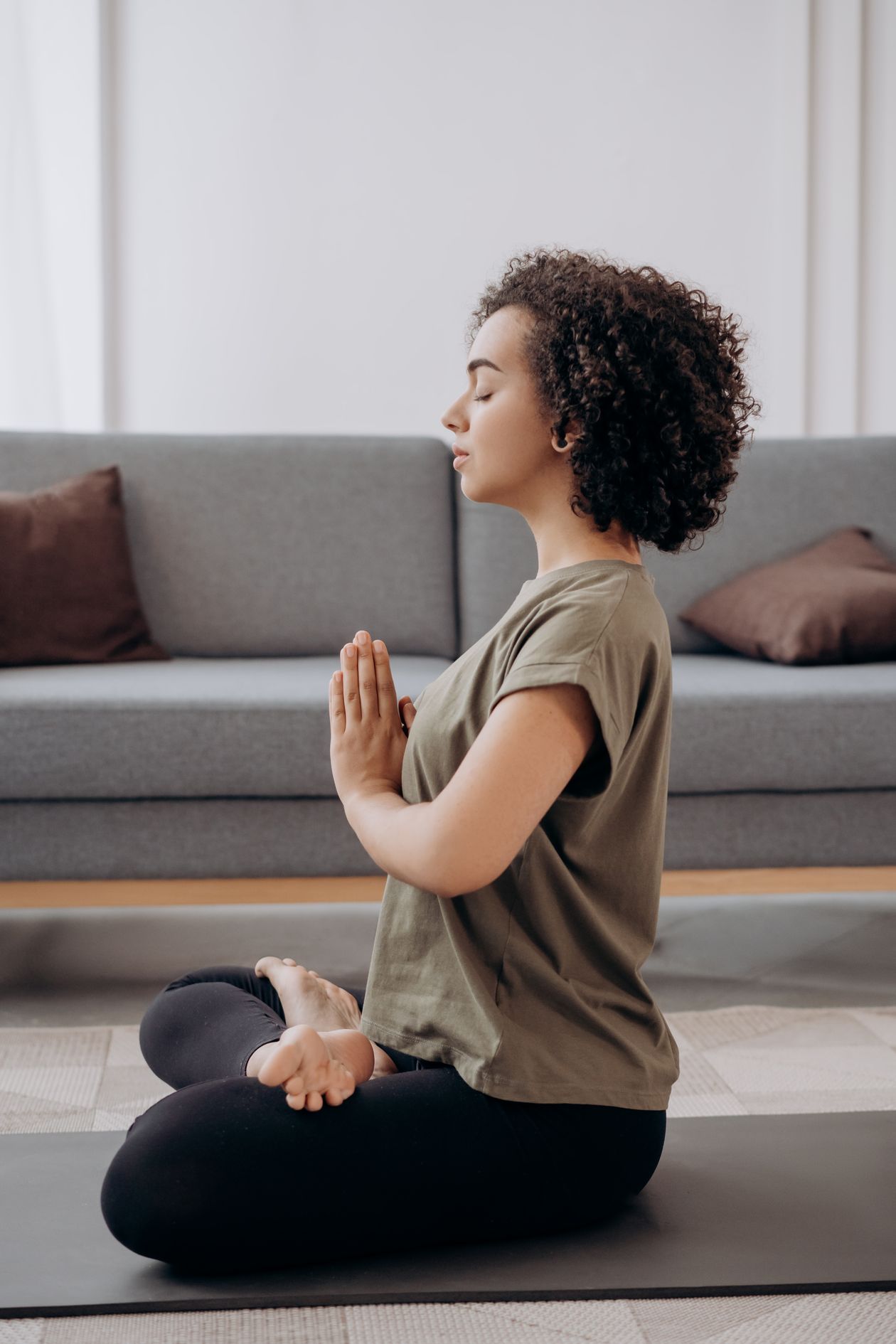 A person sitting in quiet meditation, hands in prayer position